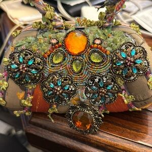 This item is a retired Mary Frances handbag featuring a pastel floral design